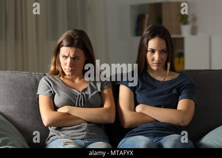 Vorderansicht Porträt von zwei anfry Freunde sich zu Hause in der Nacht auf einer Couch im Wohnzimmer zu Hause sitzen ignorieren Stockfoto