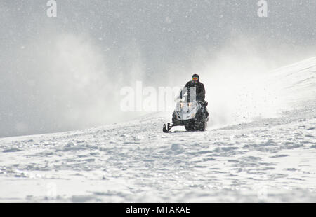 Ein Mann, der Sport Motorschlitten in den Bergen Stockfoto