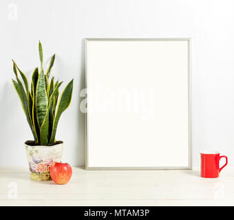 Silver frame Mockup mit Übertopf, Tasse und Apple auf Holzregal. Leeren Rahmen mock up für Presentation Design. Template Rahmen für moderne Kunst. Stockfoto