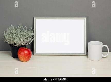 Frame mockup mit Übertopf, Tasse und Apple auf Holzregal. Leeren Rahmen mock up für Presentation Design. Template Rahmen für moderne Kunst. Stockfoto