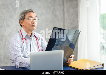 Arzt holding Suchen an x-ray film des Patienten Stockfoto