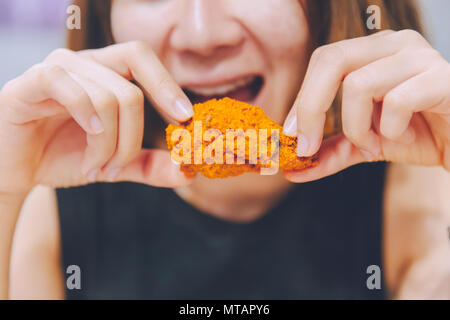 Mädchen Essen lecker lecker gebratenes Huhn Flügel Stockfoto