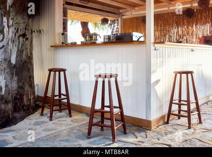 Drei braun Holz Hocker um einen Außenpool Urlaub cafe bar Stockfoto