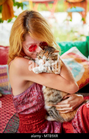 Natürliche posing blonde Frauen an 30 s umarmen eine Katze mit Liebe und Zärtlichkeit Stockfoto