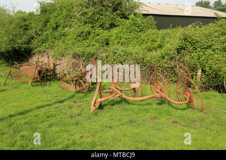 Abgebrochene rostigen alten landwirtschaftlichen Maschinen in einem Bereich, in Gloucestershire, England, UK. Stockfoto