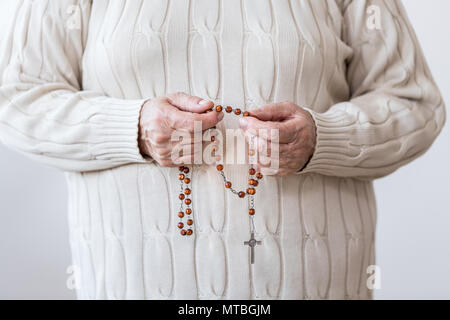 Close-up von religiösen Menschen mit rot Rosenkranz in der Kirche beten Stockfoto