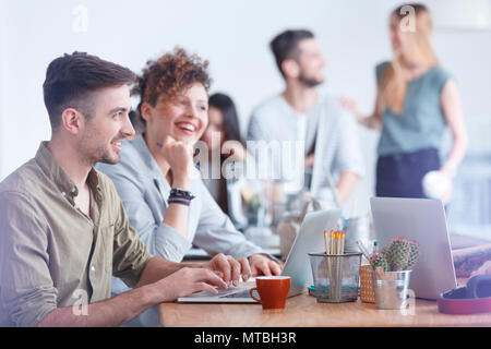 Gruppe von Kolleginnen und Kollegen bei einer Kaffeepause in einer interessanten Diskussion Stockfoto