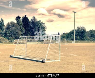 Die Fußball-Ziel im Sommer. Leer Ausbildung Tor für klassische fotbal auf grünem Gras Spielplatz. Bäume rund um das Stadion Stockfoto