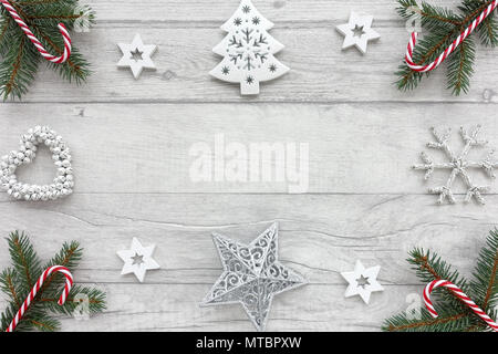 Weihnachten Hintergrund mit Tannenbaum Zweige, Zuckerstangen, weiße Sterne, Weihnachtsbaum, Weihnachten Dekoration und einem Herz aus Glocken. Stockfoto