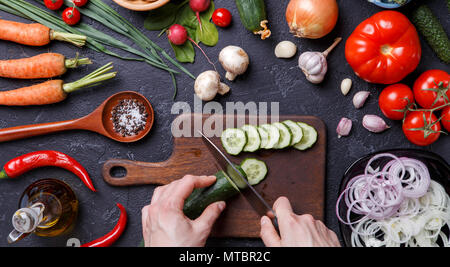 Bild oben auf frisches Gemüse, Pilze, Schneidbrett, Öl, das Messer, die Hände von Cook Stockfoto