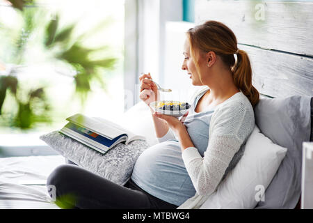 Schwangere Frau entspannen im Schlafzimmer Stockfoto