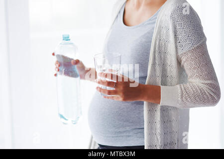 Nicht erkennbare schwangere Frau Trinkwasser Stockfoto