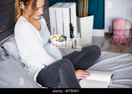 Junge schwangere Frau zu Hause ausruhen Stockfoto