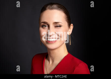 Porträt der jungen Frau zwinkerndes Auge. Schließen Portrait auf schwarzem Hintergrund. Stockfoto