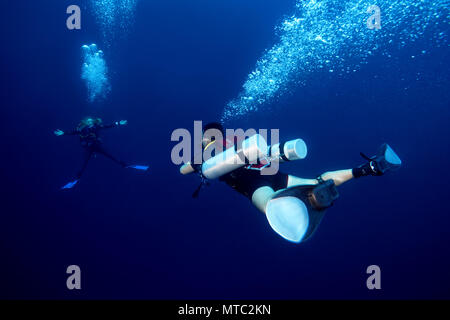 Zwei Taucher mit sidemount Mann und Frau hängt sich im blauen Wasser und wartet vergeht Dekompressionszeit auf Safety Stop Stockfoto