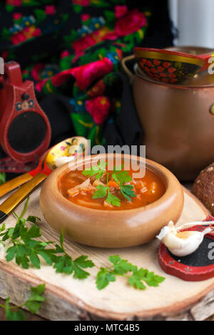 Traditionelle ukrainische Rüben Suppe Borschtsch in Holzschale mit Knoblauch Brötchen Pampushka und trocken geheilt Schweinebauch auf rustikalen Holztisch Stockfoto