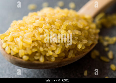 Trockene Bulgur weizen in hölzernen Löffel/Bulgur. Organisches Produkt. Stockfoto