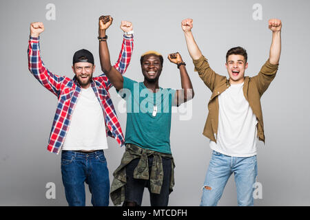 Drei junge fröhliche Männer Fußball-Fans feiern über Gelb Hintergrund isoliert Stockfoto