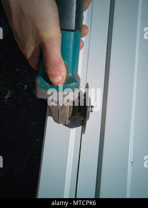 Der Master schneidet das Blech auf die gezeichnete Linie Stockfoto