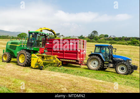 Schull, Irland. 30 Mai, 2018. An einem sonnigen Tag, Hurley ist Vertragspartner von West Cork sammeln, Gras, das für Silage mit einem Feldhäcksler John Deere 7500 und New Holland Traktoren geschnitten worden ist. Credit: Andy Gibson/Alamy Leben Nachrichten. Stockfoto