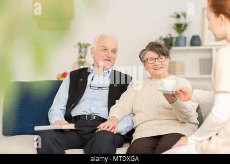 Paar der älteren Leute mit einem freundlichen Betreuer Stockfoto