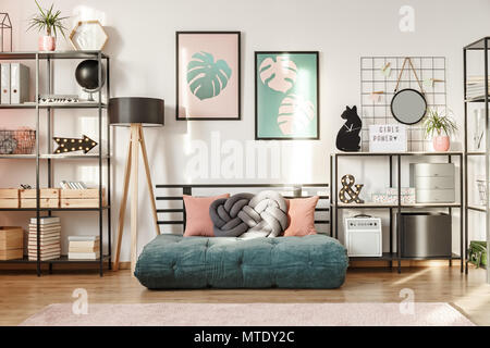 Emerald futon mit Kissen in einem modernen Wohnzimmer Interieur mit metallregale und botanischen Poster Stockfoto