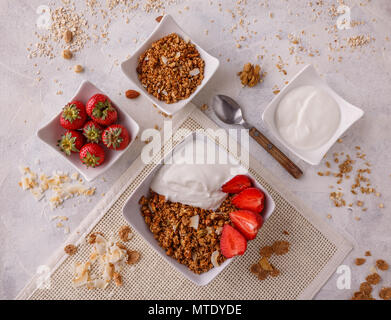 Schüssel mit hausgemachtem Müsli mit Joghurt und frischen Erdbeeren Stockfoto