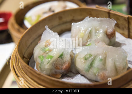 Dim Sum, traditionelle kantonesische Knödel, in Bambus Steamer gegart Stockfoto