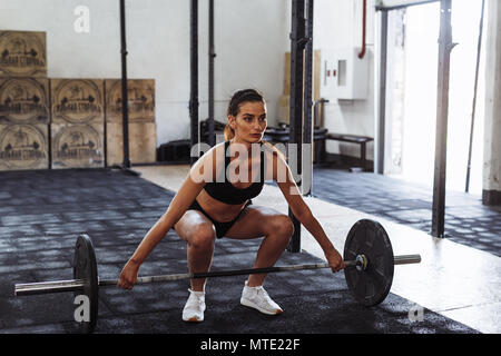 Junge Frau Trainieren mit einem barbell in einem Sport Club, hockt tun Stockfoto