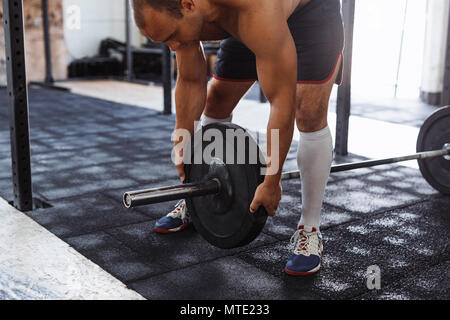 7/8 Schuß des Menschen Vorbereitung barbell in Training Fitnessstudio Stockfoto