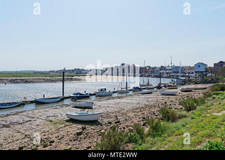 Ein Blick zurück vom Kai bis zur Stadt Wells-next-the-Sea bei Ebbe mit kleinen Booten entlang einem Steg gebunden Stockfoto