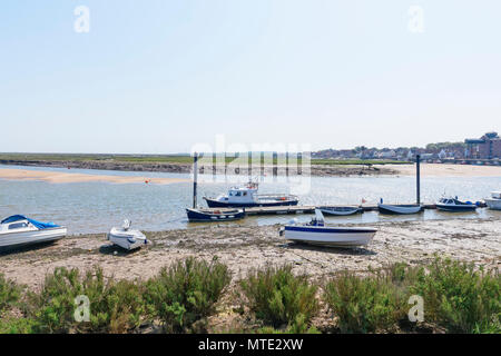 Ruderboote und Motorboote sind neben einem kleinen Steg bei Ebbe an Wells-next-the-Sea gebunden Stockfoto