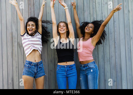 Multiethnische Gruppe von weiblichen Freunde, Spaß, Springen mit heben die Hände Stockfoto