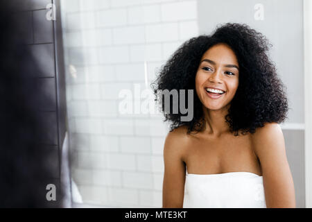 Portrait einer jungen Frau, die gerne im Bad, während Sie in ein Handtuch gewickelt Stockfoto