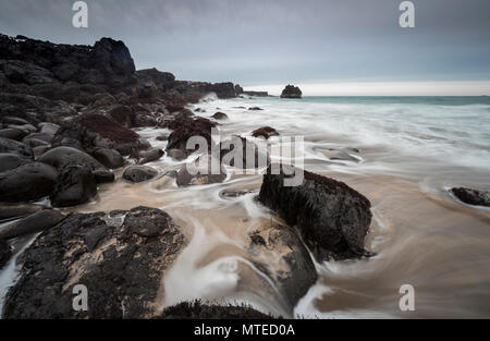 Skarðsvík Strand, Sandstrand mit großen runden schwarzen vulkanischen Felsen, Wellen am Meer, schlechtes Wetter, Lampe Belichtung, West Island Stockfoto