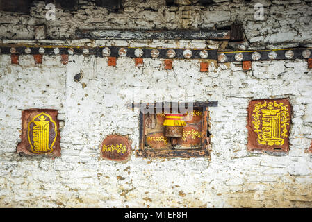 Wandmalerei und Gebet Mühle an der Klostermauer, Bumthang, Himalaya, Königreich Bhutan Stockfoto