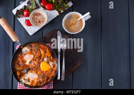 Shakshuka, gebratene Eier in Tomatensauce für Osterbrunch. Platz kopieren, Flach. Ansicht von oben. Stockfoto