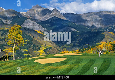 Aspen Bäume biegen Sie Gold im Telluride Golf Club über Telluride, Colorado, mit der felsigen Bergen im Hintergrund, im späten September. Stockfoto