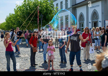 Paar Animateure unterhalten die Kinder und öffentliche Seifenblasen auf dem Platz in Konstanz Stockfoto