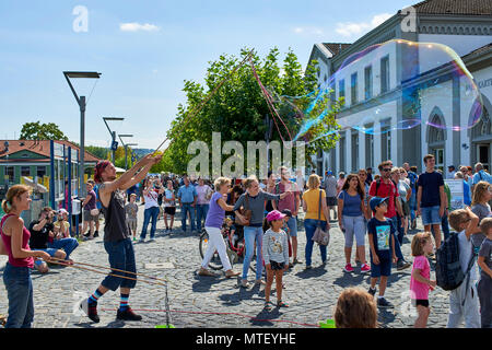 Paar Animateure unterhalten die Kinder und öffentliche Seifenblasen auf dem Platz in Konstanz Stockfoto