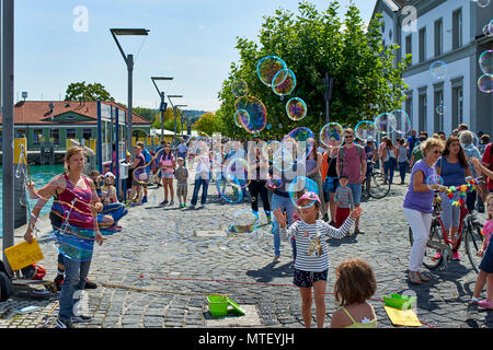 Paar Animateure unterhalten die Kinder und öffentliche Seifenblasen auf dem Platz in Konstanz Stockfoto