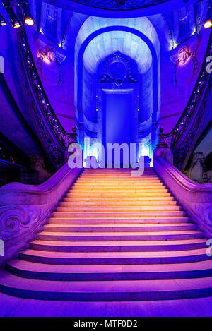 Die große Treppe im Grand Palais in Paris während einer Ausstellung leuchtet mit einem blauen und violetten Licht. Stockfoto