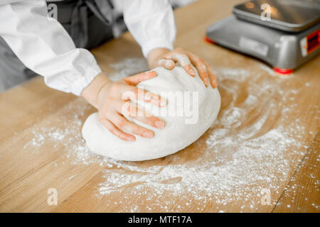 Baker bilden daugh mit Händen zum Backen auf dem hölzernen Tisch in der Fertigung Stockfoto