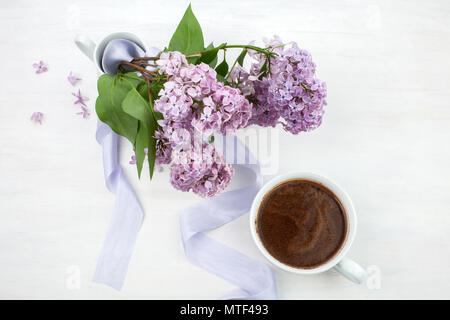 Blumige Komposition aus schönen lila lila auf weiß Holz- Hintergrund mit Tasse Kaffee. Stockfoto