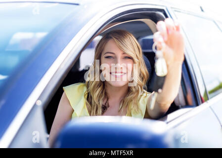 Frau sitzt im Auto und halten ein weißes leeres Plakat. Stockfoto