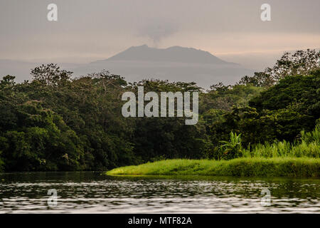 Vulkan am Horizont hinter einem Kanal bei Pacuare am Atlantischen Ozean bei Reventazón, Costa Rica Stockfoto