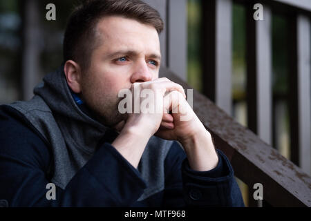 Traurig kaukasischen Mann allein sitzen und thinling über Probleme. Stockfoto