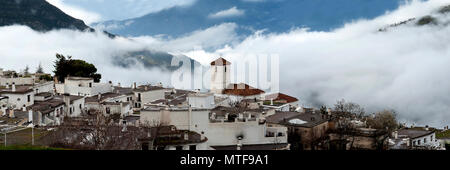 Die alpujarran Dorf Capileira mit seiner katholischen Kirche gelegen, hoch über den Wolken in den Bergen der Sierra Nevada in Spanien Andalusien. Stockfoto
