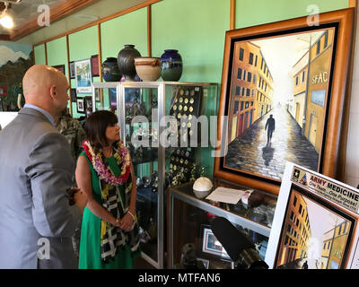 SCHOFIELD BARRACKS, Hawaii (24. April 2017)---The Second Lady der Vereinigten Staaten, Karen Pence, Ansichten erstellt ein Gemälde von einem Ehegatten der 25. ID Soldat, Cindy Manga. Das Gemälde zeigt eine schattierte Figur, ein Soldat mit einem Stock zu Fuß durch einen dunklen Flur. Während die Flur weitergeht, wird es leichter. Am Ende des Tunnels ist die Quelle des Lichts: der Soldat Frau und zwei Kindern auf ihn wartet und ihn durch seine Reise zu unterstützen. An der linken Seitenwand in der Szene sind Zimmer mit jeder Abteilung, die die Familie durch geholfen. Auf der rechten Seite ein Schild, das liest: SFAC, steht für S Stockfoto