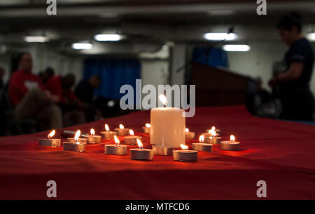 Arabischen Golf (24. April 2017) Segler beobachten, ein Moment der Stille, in der Erinnerung an den Holocaust Veranstaltung an Bord der Flugzeugträger USS George H.W. Bush (CVN 77) (GHWB). GHWB ist in den USA der 5. Flotte Bereich für Maßnahmen zur Erhöhung der Sicherheit des Seeverkehrs auf die Verbündeten und Partnern zu beruhigen bereitgestellt, und der Freiheit der Schiffahrt und des freien Handels in der Region erhalten. Stockfoto